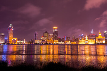 Fototapeta na wymiar Night view of the bund at a cloudy day after raining with golden light in Shanghai, China
