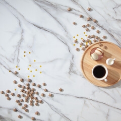 Flat lay composition of coffee, milk and macarons on wooden tray on side with gold sparkles