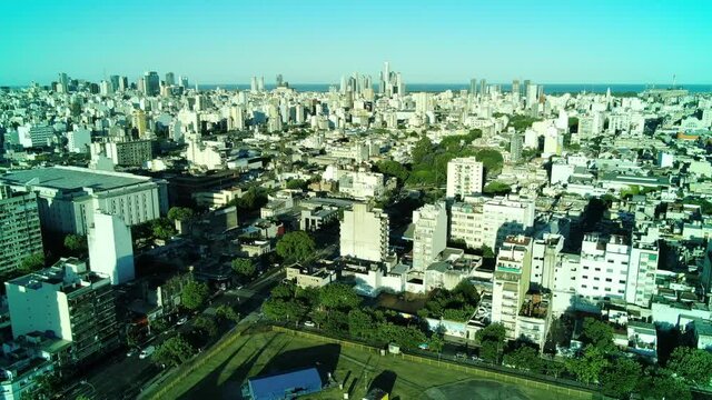 Vista a&eacute;rea de una ciudad con grandes arboledas, volando hacia los edificios m&aacute;s altos de la ciudad.