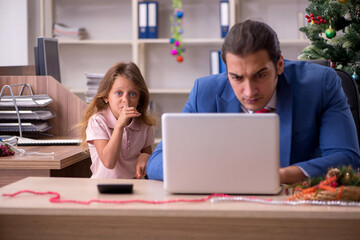 Young male employee celebrating Christmas at workplace with his