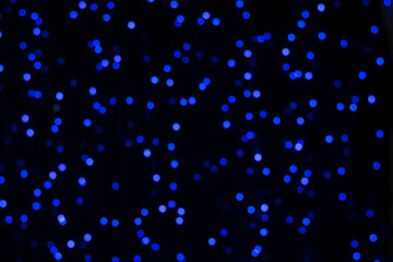 Blurry background of small blue bokeh lights.