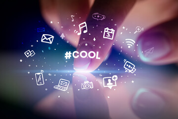 Finger touching tablet with drawn social media icons and #COOL inscription, social networking concept