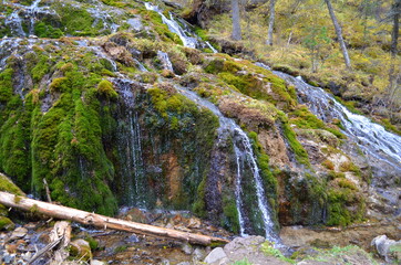 Unusual beautiful waterfall in the Siberian forest.