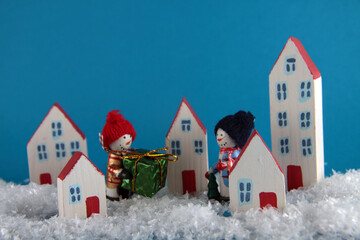 Two snowmen with a gift walking snowcovered city close up. Christmas concept