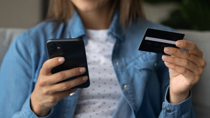 Wide banner panoramic view of woman hold modern smartphone and credit card shopping online. Female customer make payment purchase on cellphone, use secure banking service system on gadget.