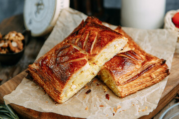 Freshly baked traditional homemade cabbage pie. Cake of puff pastry in the section on the parchment.