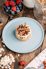 Chocolate dessert with soft milk cream. Tartlet with chocolate chips on a wooden background.