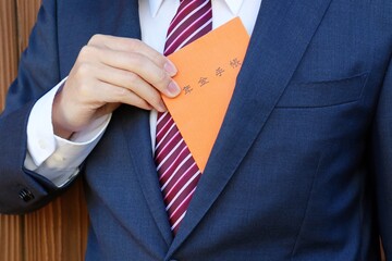 年金手帳を持つスーツを着た男性