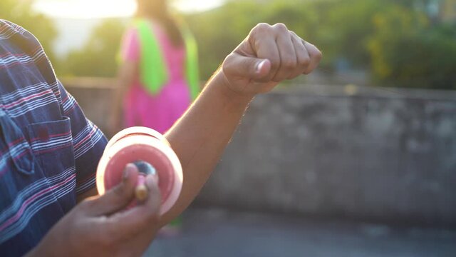 Man holding a charki phirki thread spool in the crook of his elbow and winding it with the other hand to ensure taughtness for the famed kite fighting festival of makar sankranti uttarayana
