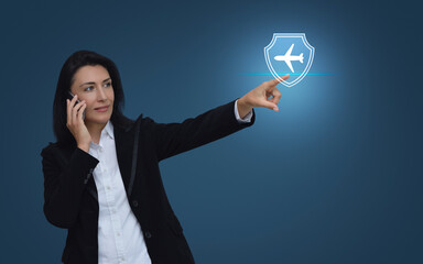 Caucasian businesswoman talking on her cell phone and pointing finger to airplane with shield flat icon over gradient light blue background, Business travel insurance and safety online concept