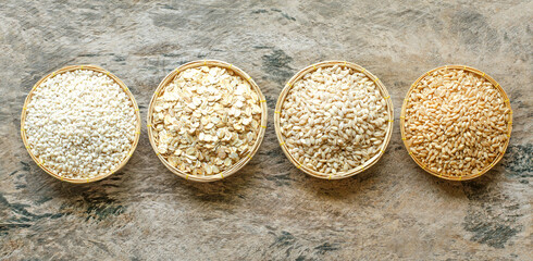 Collection of dry organic pearl barley and wheat weed in wooden bowl on grunge background