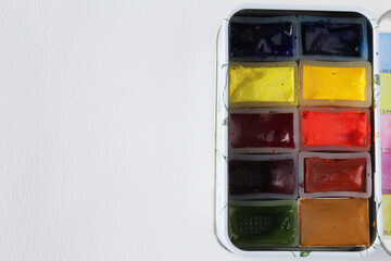 Watercolor multicolor paints on white paper with copy space for text or picture. Artist palette. Art creative background for sketchbook, coloring book