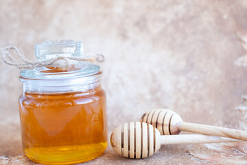 Glass can full of honey and wooden stick