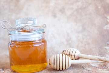 Glass can full of honey and wooden stick