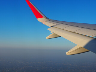 The wing of the plane seen from the window Clear sky