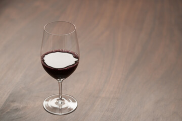 Red wine in wineglass on black walnut table with copy space