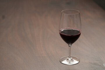 Red wine in wineglass on black walnut table with copy space