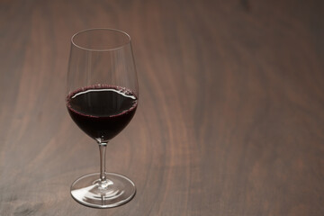 Red wine in wineglass on black walnut table with copy space