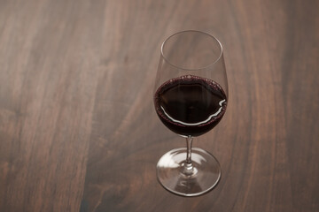 Red wine in wineglass on black walnut table with copy space