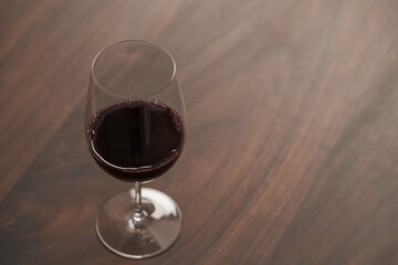 Red wine in wineglass on black walnut table with copy space