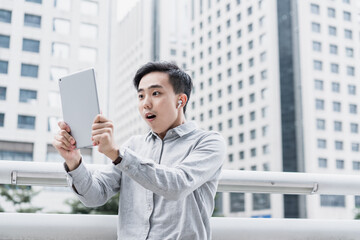 Business people holding tablet in surprise 