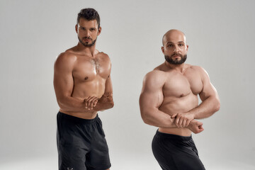 Young muscular male athletes posing showing side biceps