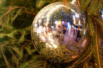 Close up ball, lights and branches of a tree in winter, Christmas background, cozy and warm feelings