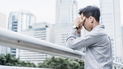 depressed business people against the railings with hands covering his face