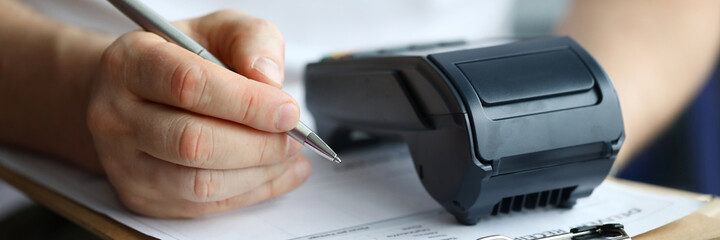 Man fills in home delivery mail document on box. Banking application. POS-terminal provides...