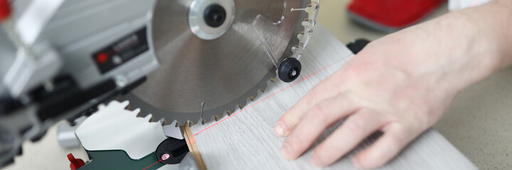 Man uses circular saw table while cutting laminate. Laminate laying technology with Click lock....