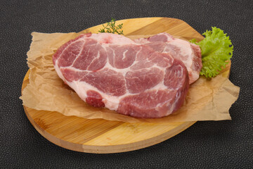 Raw pork steak over wooden board