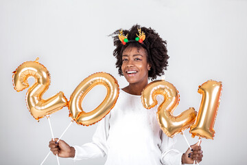 Happy young African American woman holding 2021 gold color balloons for celebrate merry Christmas and happy new year on white background, celebration and decoration for holiday event concept