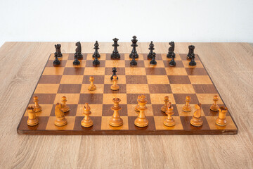 Chessboard with pieces. Arrangement of the pieces stems from an opening known as Queen's Gambit.