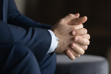 Patience and concentration. Close up view of young businessman in classic suit sitting with hands...