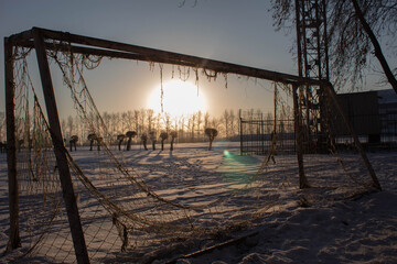 Soccer goal with a broken net in the winter stadium.