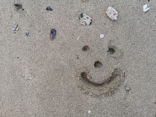 smiley drawn in fine sandy beach on vacation