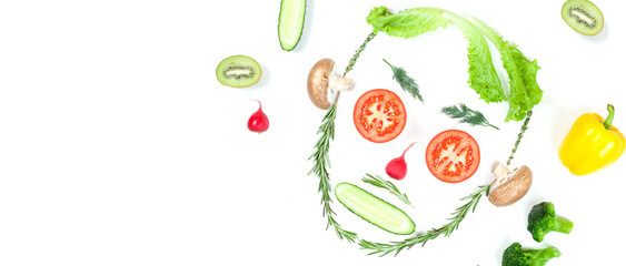Funny face from different vegetables tomatoes, cucumber, radish, dill and rosemary isolated on white background. Healthy eating and vegan food concept. Kitchen