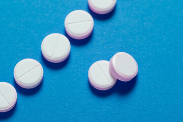 Set of round medical tablet pills on blue background