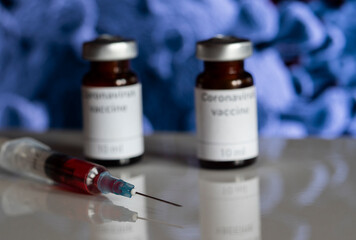 In this photo illustration, vials labelled as Coronavirus vaccine and a syringe