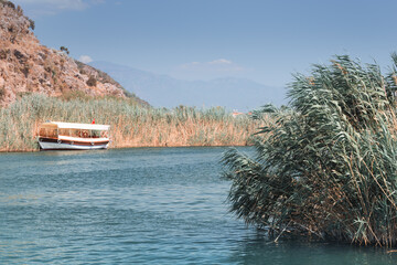 A tourist boat ferry is waiting for tourists for a sightseeing tour and a tour of the Dalyan river...