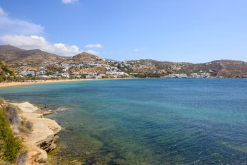 The port of Ios Island in Greece, a picturesque bay with a small settlement and long sandy beach, a famous tourist destination. Cyclades Islands, Greece