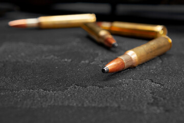 Cartridges for rifle or carbine on dark grey background close up