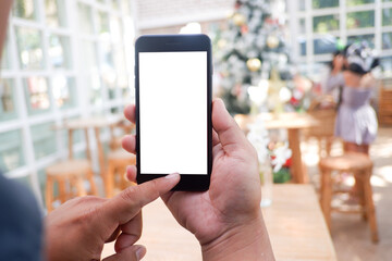Mockup picture of business man's hands holding smart phone with white blank screen in modern place.