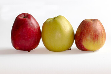 Pommes bicolores, vetre et rouge en ligne sur fond blanc 
