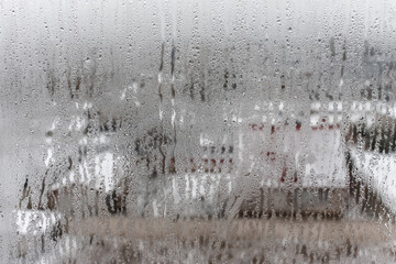 Natural drops of water flow down the glass, high humidity in the room, condensation on the glass window. Neutral colors. Excellent background with condensation drops texture