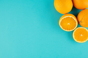 Light blue background with cut and uncut oranges in upper right corner