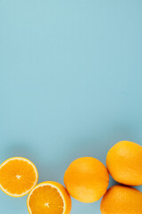 Fresh ripe juicy oranges on light blue background. Summer, harvest, vitamins concept