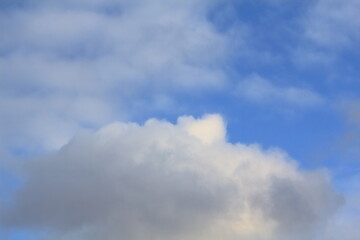 Light clouds against the blue summer sky create a beautiful background. A beautiful painting created by nature in spring.