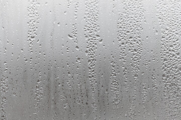 Close up water drop on grey background, misted glass with droplets of water draining down. Dripping...