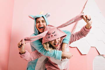 Fascinating girls in bright kigurumi spending weekend morning together. Lovable female model in...
